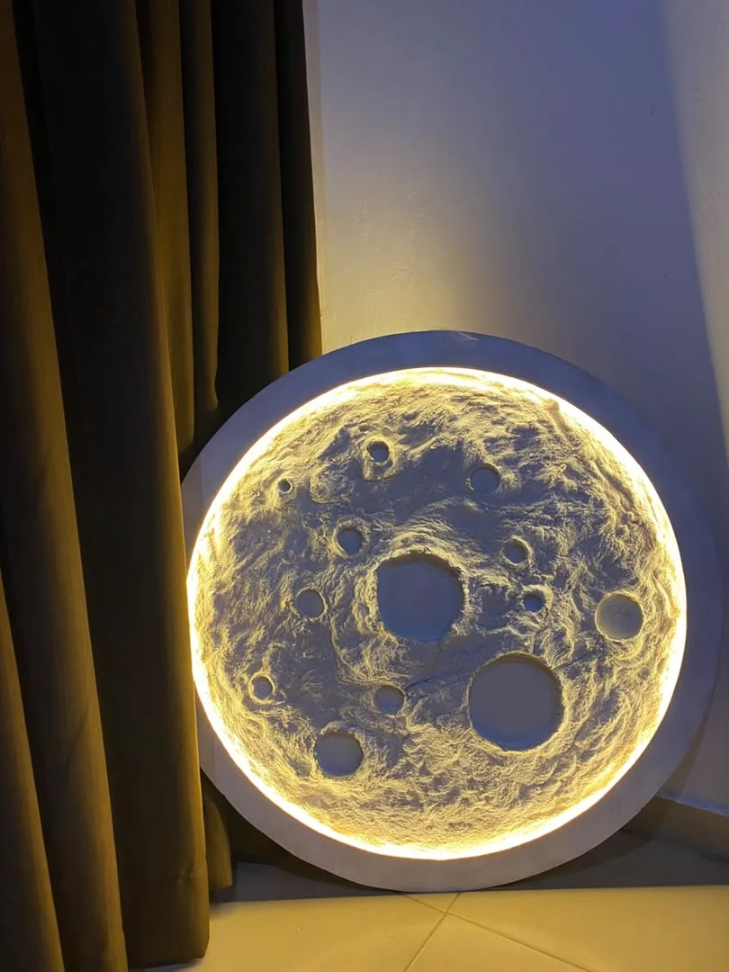 Circular textured artwork illuminated with warm yellow light